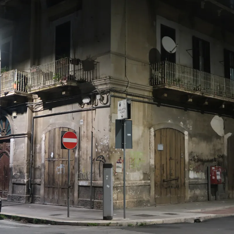 Roh budovy v noční ulici.