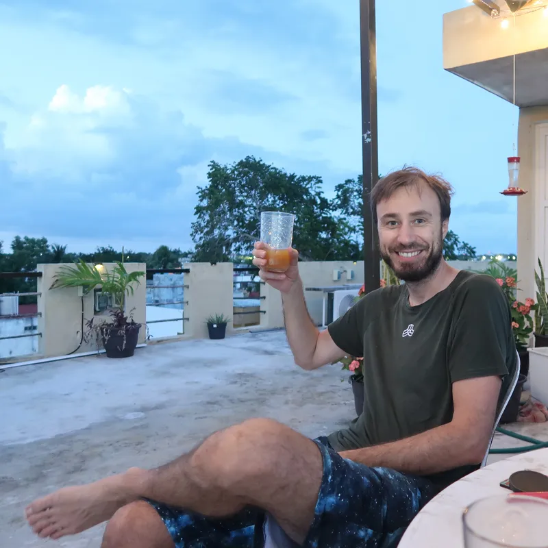 AUtor blogu připíjí sklenicí tibi krystalů. Sedí na terase, v pozadí je strom.