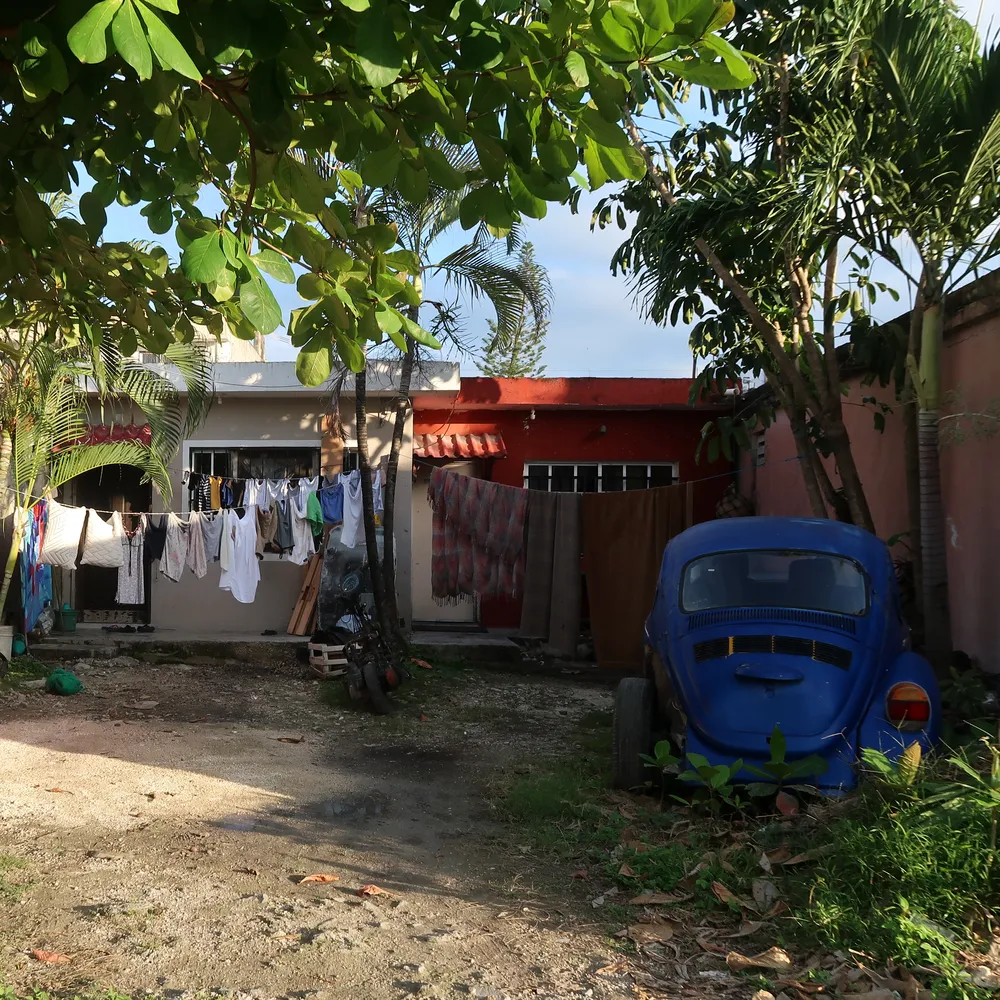 Jeden ze dvorů v San Gervasio - vlevo se suší prádlo na šňůře, vpravo se rozpadá starý autovrak