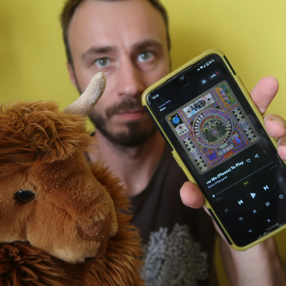 Autor podcastu s býkem Beladorem a mobilem, na kterém běží aplikace Tidal