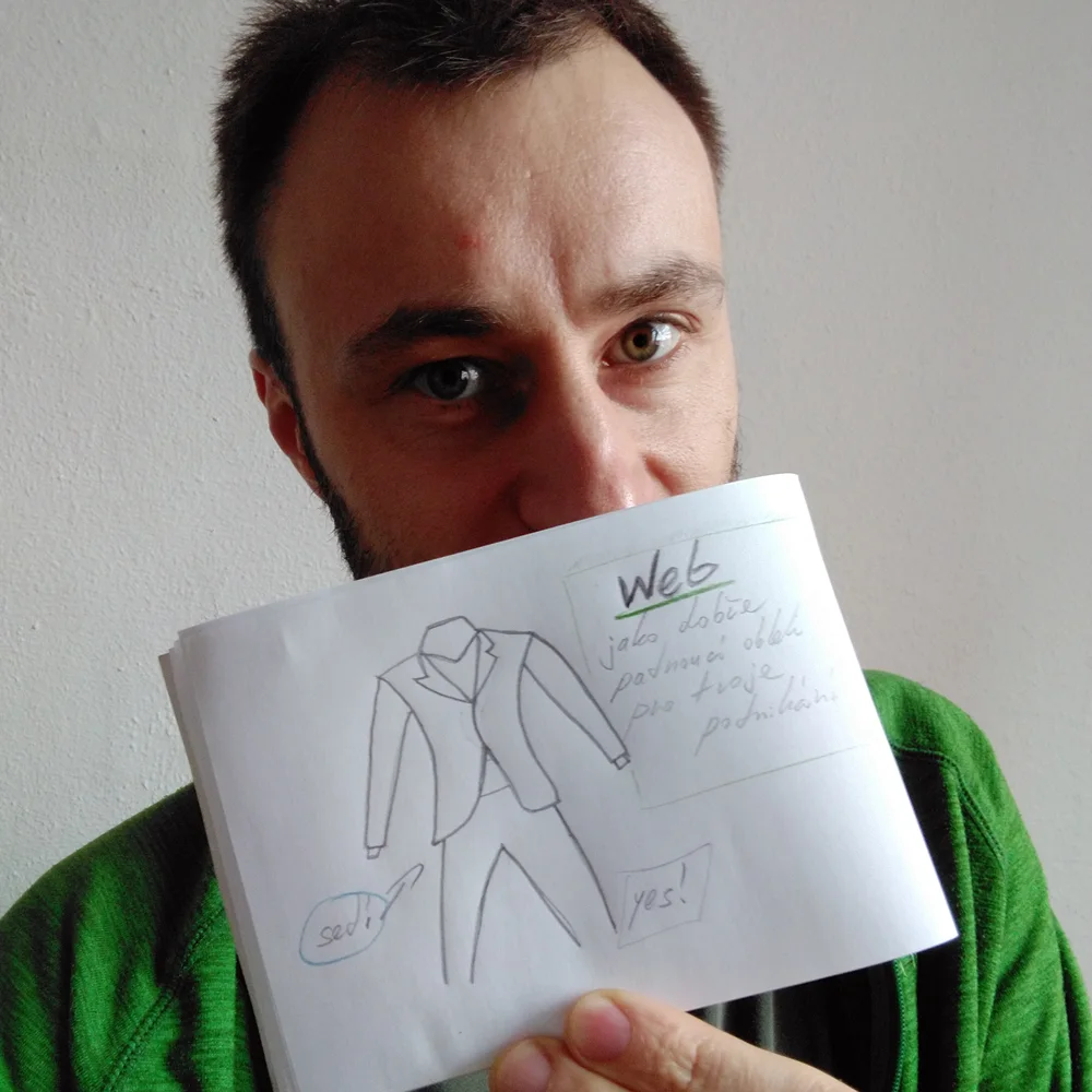 Autor webu drží blok s kresbou web jako dobře padnoucí oblek pro tvoje podnikání